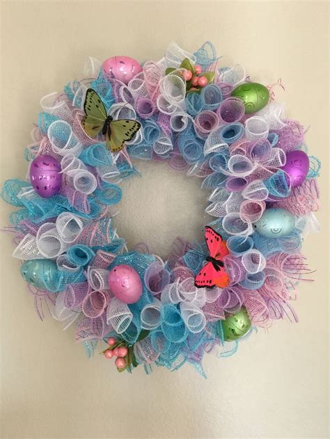 An Easter Wreath With Colorful Eggs And Butterflies On The Front