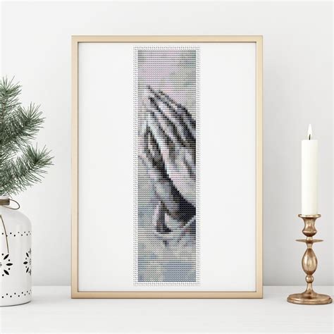 A Cross Stitch Picture With A Candle Next To It