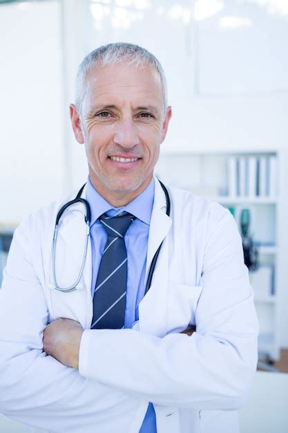 Premium Photo Happy Male Doctor Looking At Camera With Arms Crossed