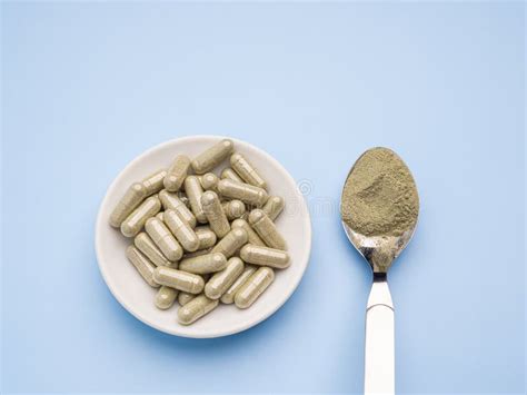 Close Up Of Andrographis Paniculata Powder In Spoon And Capsules Are In