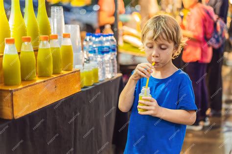 Premium Photo Boy Drinking Sugar Cane Juice On The Asian Market