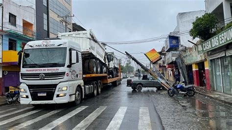 Carreta transportando caçambas arrasta fios e derruba poste no centro