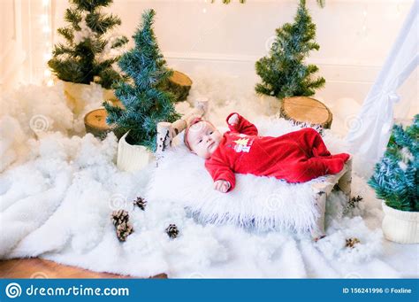 Cute Newborn Baby In A Christmas Costume On A Wooden Bed Stock Photo