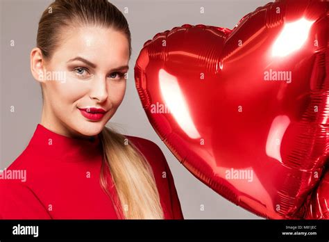 Beautiful Blonde Smiling Woman Holding Red Balloons Looking At Camera