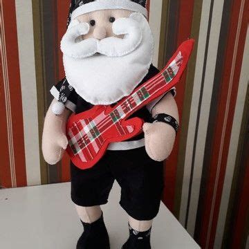 A Stuffed Santa Holding A Red Guitar And Wearing Black Pants With A