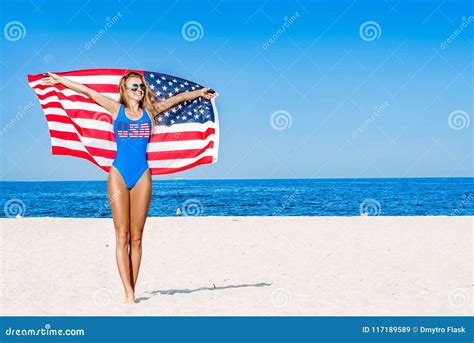 Beautiful Patriotic Cheerful Woman Holding An American Flag On The