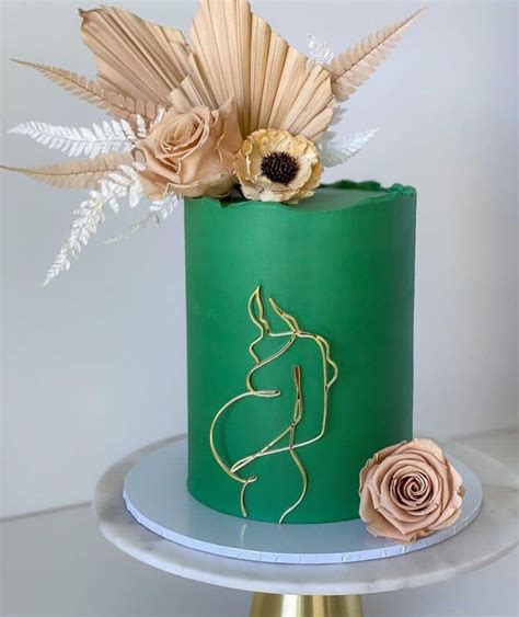 A Green And Gold Cake With Flowers On Top