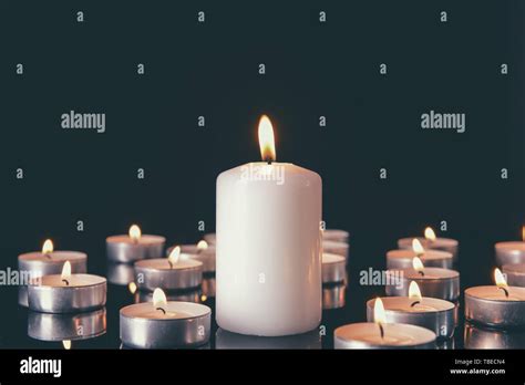 Many Burning Candles As Symbol Of Mourning On Dark Background Stock