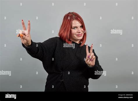 Young Redhead Fat Lady In Black Sweater Happy Woman Shows Two Fingers