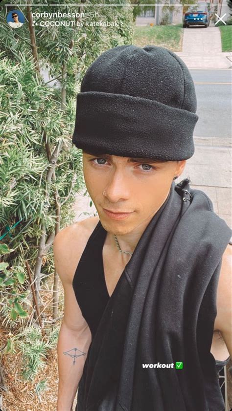 A Man Wearing A Black Hat And Scarf On His Head Is Looking At The Camera