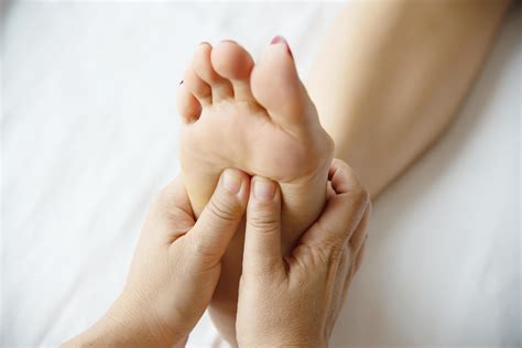 Woman Receiving Foot Massage Service From Masseuse Close Up At Hand And