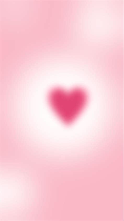 A Blurry Pink Background With A Heart Shaped Object In The Center And