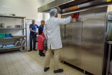 Food Inspector In Uniform Examines The Kitchen Of The Restaurant