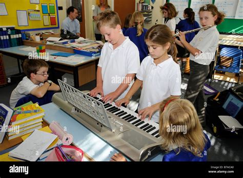 Piano Playing Pupils In A Primary School Classroom England Uk Stock