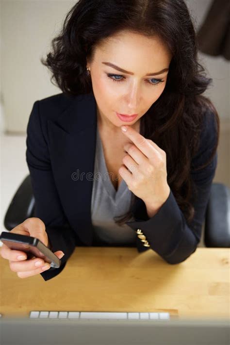 Professional Business Woman Sitting At Desk With Mobile Phone Stock