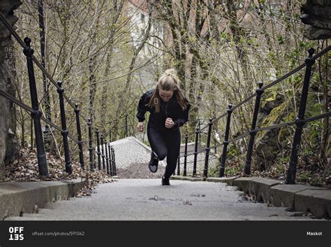 Full length of fit woman moving up stairs stock photo - OFFSET