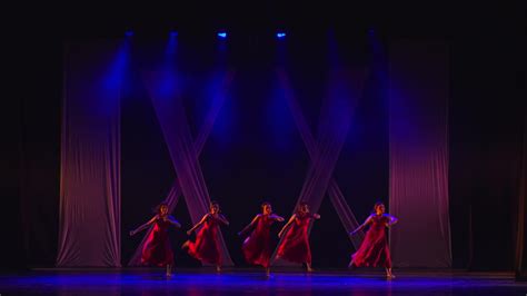 Silhouetted Dancers On Stage With Red Lighting And Geometric Patterns