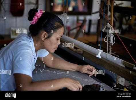 Thai Woman Working At A Traditional Wooden Weaving Loom Producing Woven