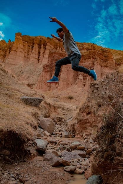 Premium Photo Low Angle View Of Man Jumping On Rock Against Sky