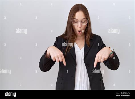 Beautiful Brunette Woman Wearing Business Jacket And Glasses Pointing Down With Fingers Showing
