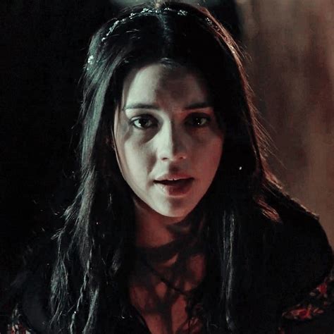 A Close Up Of A Person With Long Black Hair And An Evil Look On Her Face