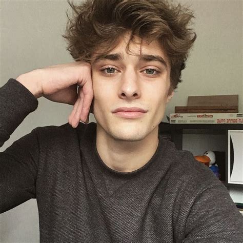 A Young Man Is Sitting In Front Of A Desk With His Hand On His Head