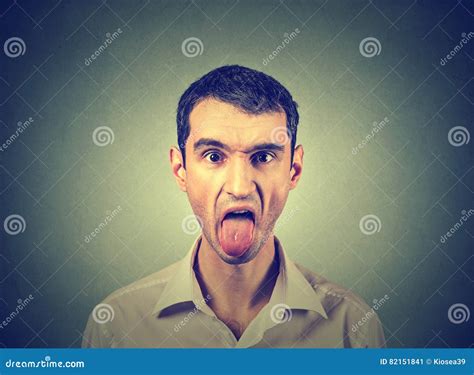 Retrato Del Hombre Joven Que Se Pega Hacia Fuera La Lengua Imagen De