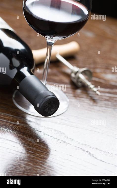 Abstract Wine Bottle Glass And Corkscrew Laying On A Reflective Wood