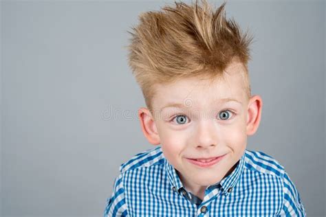 Retrato Do Menino Feliz Elegante Que Levanta Em Um Fundo Branco Foto