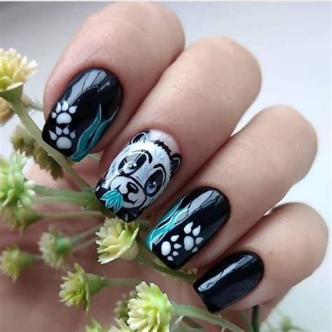 A Woman S Hand With Black And White Nail Polish On It Holding Flowers