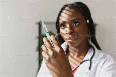 Front View Of Young African American Female Doctor Holding Syringe With