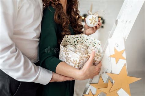 Decorating Christmas Tree Wife And Husband Holding A Box With Christmas Toys In Scandinavian