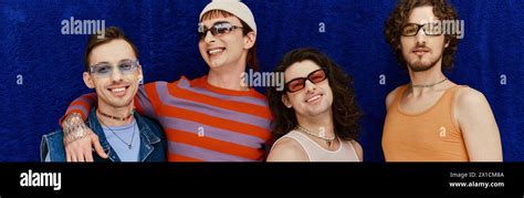 Merry Handsome Gay Men With Sunglasses In Vivid Attires Posing On Blue