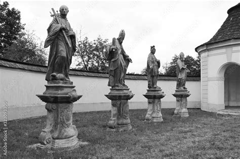 Black And White Photo Of Old Statues Of Saints At Former Cemetery In