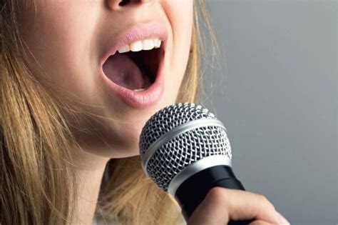 A Woman Singing Into A Microphone With Her Mouth Open And The Words