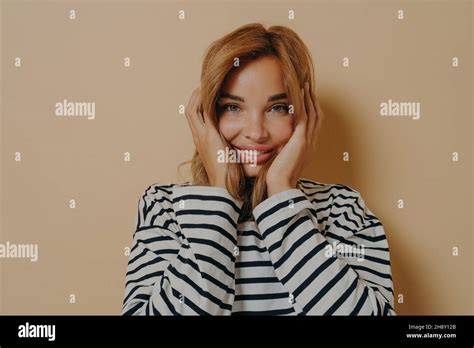 Happy Young Woman Looking At Camera With Joyful Facial Expression Holding Her Face With Both