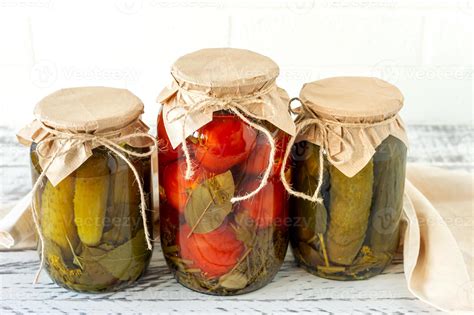 conservas caseras de tomates y pepinos en tarro de cristal sobre fondo