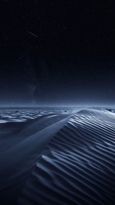 The Night Sky Is Lit Up By Stars Above Sand Dunes In The Sahara Desert