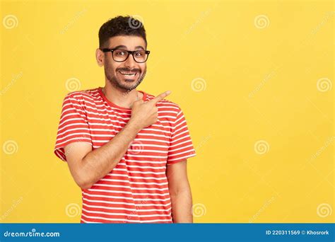 Look At Advertise Positive Bearded Man In Striped T Shirt Pointing