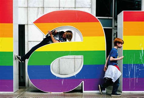 Two People Standing In Front Of A Giant Letter That Has The Number Nine