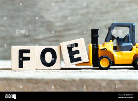 Toy Forklift Hold Letter Block E To Complete Word Foe On Wood