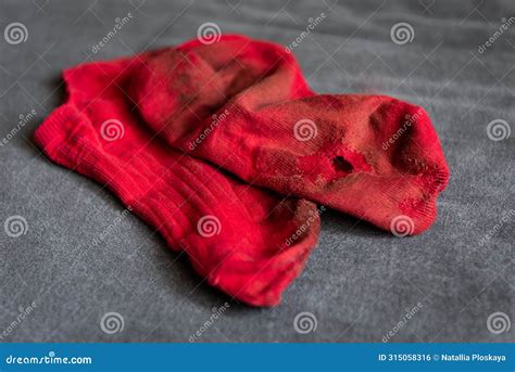 Pair Of Red Dirty And Torn Socks Lying On Bed Stock Photo Image Of