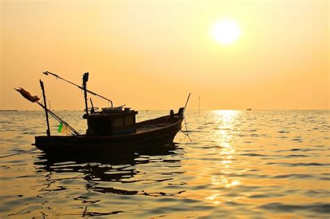 Premium Photo | Silhouette of fishing boat at sunset