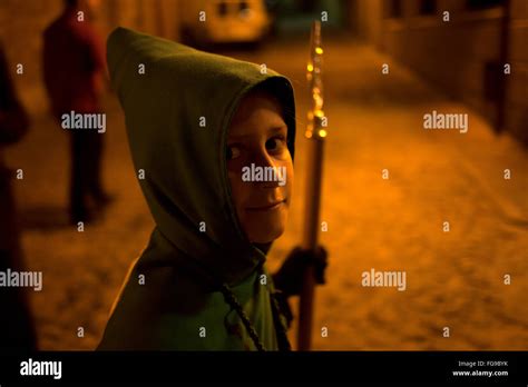 A Young Hooded Penitent Holding A Staff During An Easter Holy Week