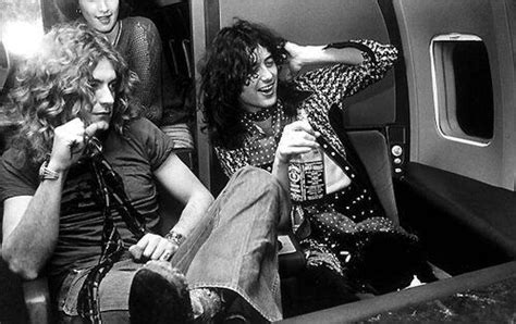 Jimmy Page Drinking A Bottle Of Whiskey Next To Robert Plant On A Plane