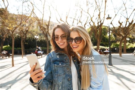 Two Amazing Smiling Women Friends Make Selfie By Mobile Phone Stock