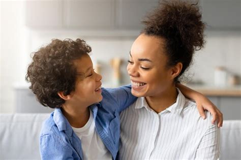 Une Mère Noire Joyeuse Et Son Fils Partagent Un Moment De Tendresse Et Sembrassent à La Maison