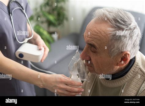 Elderly Senior Man nursing care wear oxygen inhaler device for helping ...