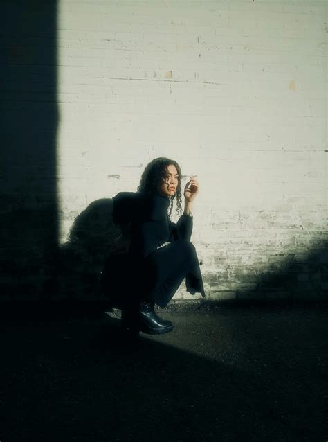 person crouching  white wall  stock photo