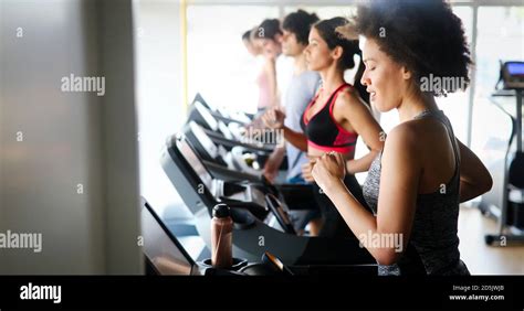 Group of people exercising in a gym cardio training and running Stock Photo - Alamy